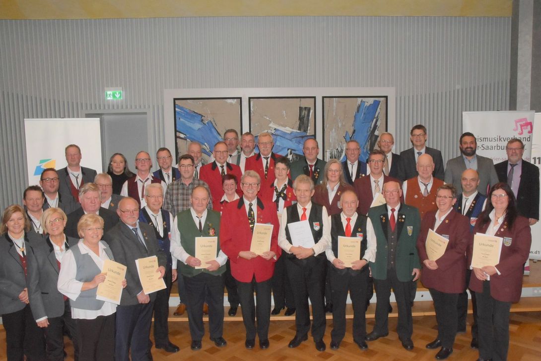 Großer Andrang beim ersten Ehrungsempfangs des Kreismusikverbandes Trier-Saarburg. Mit im Bild LMV-Präsident Achim Hallerbach, (hinten, 4.v.r.) sowie in der vorderen Reihe in der Mitte die drei für 70 und rechts und links daneben die für 60 Jahre Geehrten. Foto: Schmieder