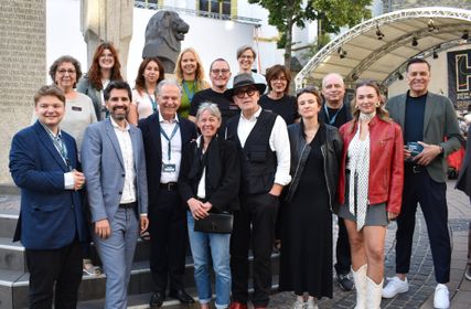 Ein Teil des Teams der Filmfestspiele mit dem Kulturminister des Landes Rheinland-Pfalz, Sven Teuber (2.v.l.), Eva Trobisch (Regisseurin des Eröffnunsgfilms, 4.v.r.) und Moderator Holger Winpahl (r.) bei der Eröffnung.