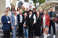 Ein Teil des Teams der Filmfestspiele mit dem Kulturminister des Landes Rheinland-Pfalz, Sven Teuber (2.v.l.), Eva Trobisch (Regisseurin des Eröffnunsgfilms, 4.v.r.) und Moderator Holger Winpahl (r.) bei der Eröffnung.