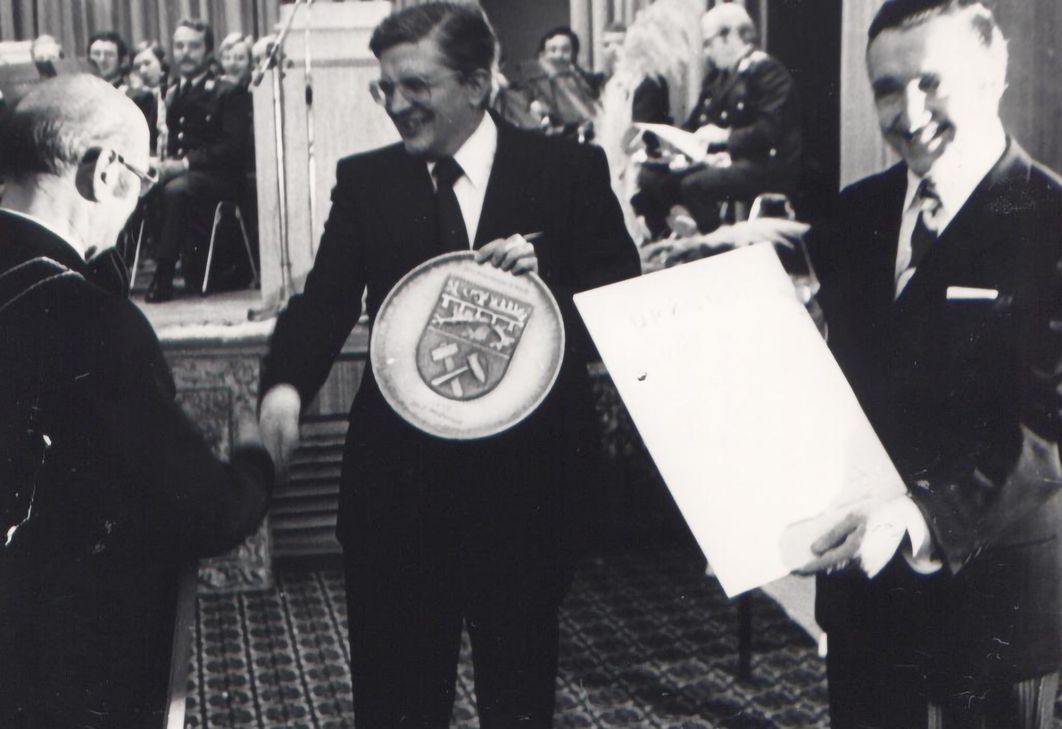 Bürgermeister Peter Giesen (l.) bedankte sich bei Innenminister Dr. Burkhard Hirsch mit einem großen Wappenteller der Stadt, während Mechernichs Stadtdirektor und Autor des Beitrags im Kreisjahrbuch, Helmut Rosen, voller Stolz die Urkunde zeigt.