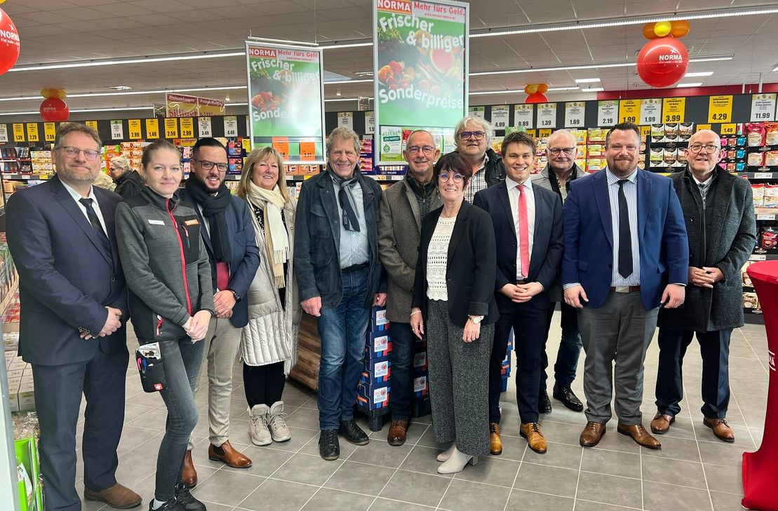 Markt- und Regionsleiter von NORMA, örtliche Politik und Familie Kirch freuen sich über die Neueröffnung des Nahversorgers in Höfen.
