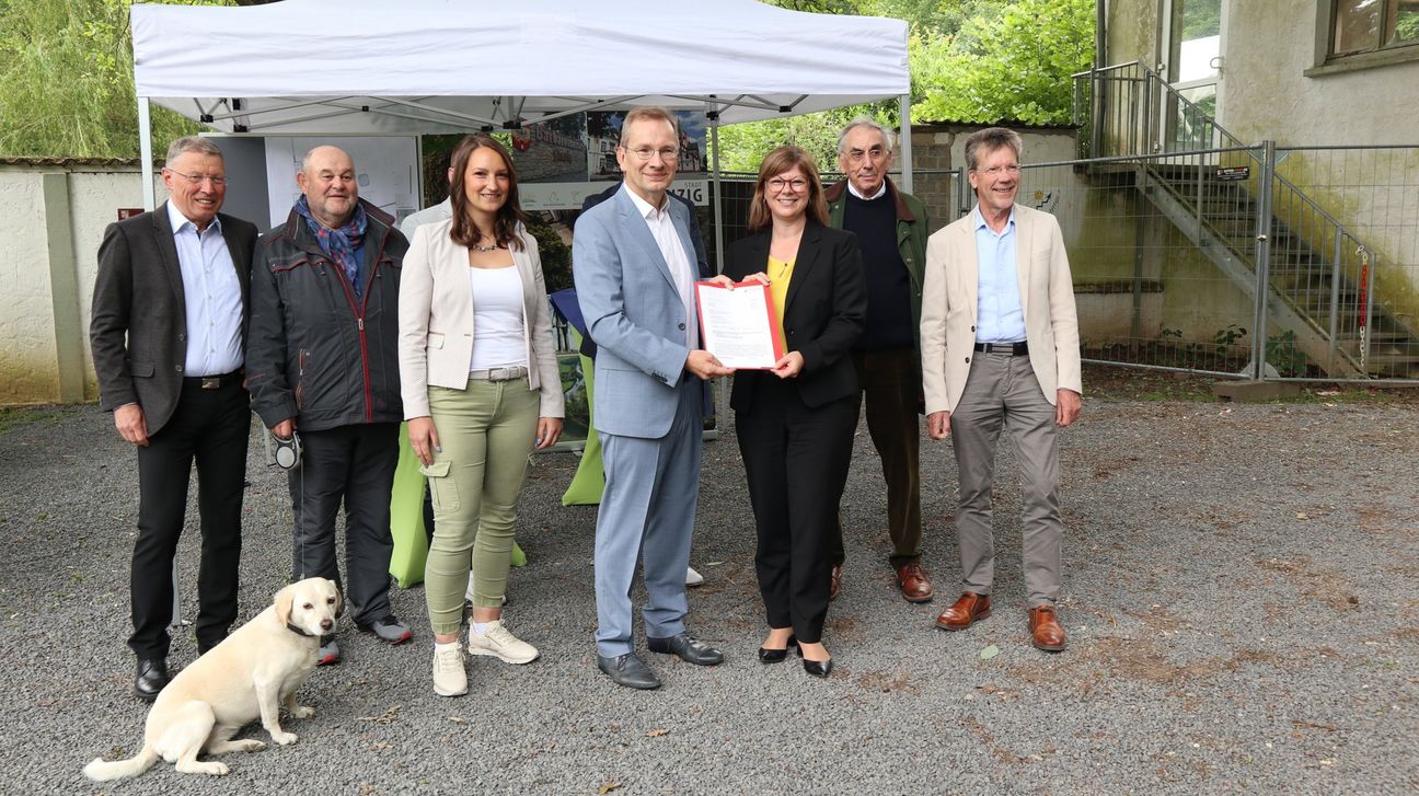 Staatssekretärin Nicole Steingaß (3. von rechts) überbrachte die frohe Botschaft: Sie übergab den Bescheid an Bürgermeieter Andreas Geron.