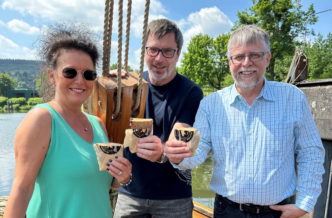 Haben die Bissula-Klappschmier in einen sicheren Hafen gebracht mit einem Ortstermin auf dem Nachbau des römischen Handelsschiffes (v.l.n.r.): Alexandra Reitz, stellvertretende Geschäftsführerin im Studiwerk, Professor Christoph Schäfer (Universität Trier) und Andreas Wagner (Geschäftsführer Studiwerk Trier)."