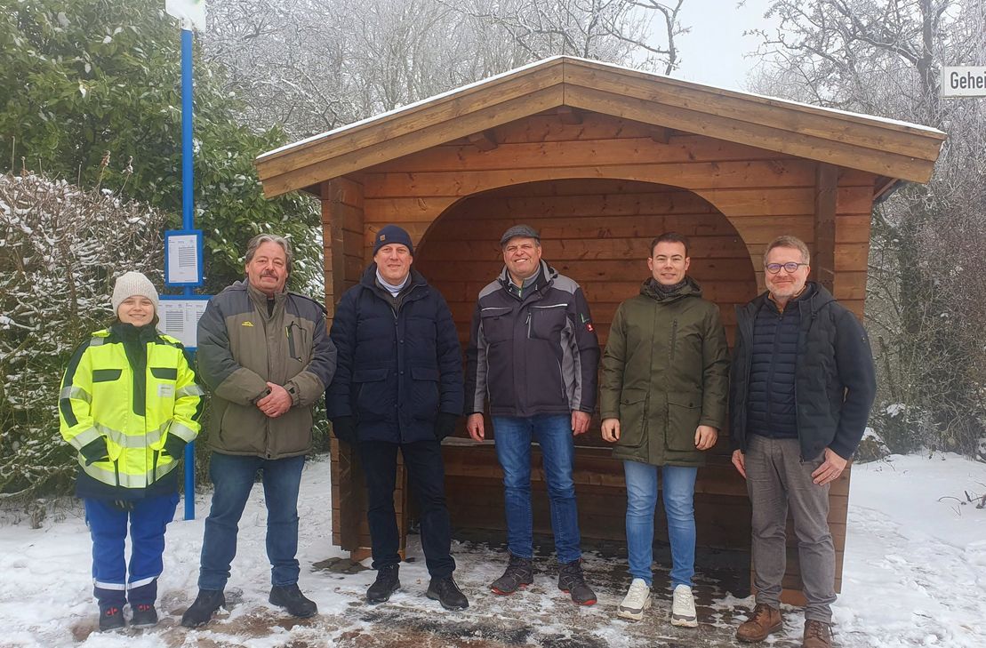 Elisabetta Pinna, Rainer Bousonville, Ortsvorsteher Reinhardt Paulus, Armin Hunsicker, Erster Beigeordneter Alexander Burger und Stadtbürgermeister Andreas Reymann an der neuen Bushaltestelle am Hosteberg