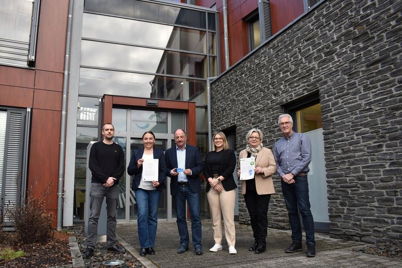 Philipp Dahlem, Barbara Schwarz (Tarifexperte und Geschäftsführerin Verkehrsverbund Region Trier VRT), Hartmut Heck, Valérie Dengler (Bürgermeister und Leiterin der Tourist-Information VG Hermeskeil), Stephanie Nickels und Matthias Breser (Bürgermeisterin und Fachbereichsleiter Organisation VG Ruwer) vor dem Rathaus der VG Ruwer in Waldrach am 31. Januar 2024.