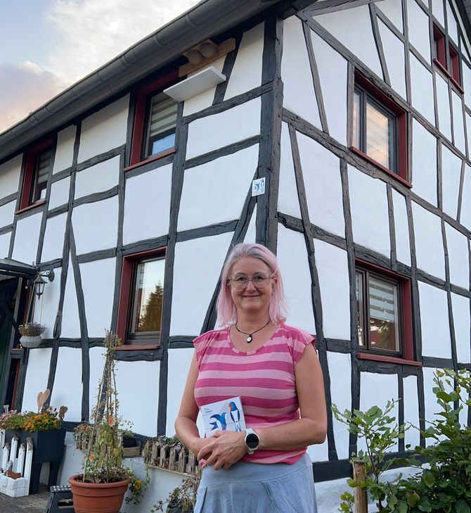 Sandra Steffens an ihrem schwalbenfreundlichen Haus - zahlreiche Nester wurden von den fröhlichen Sommerboten bezogen.