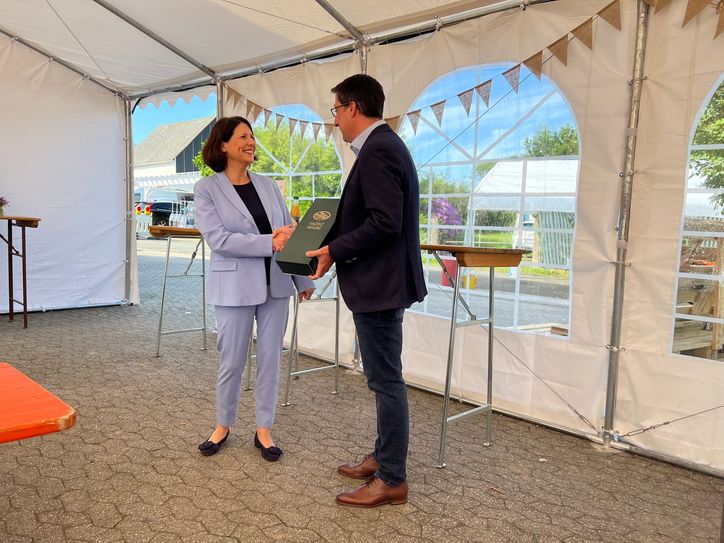 Jürgen Hoffmann übergibt Verkehrsministerin Daniela Schmitt ein kleines Präsent.