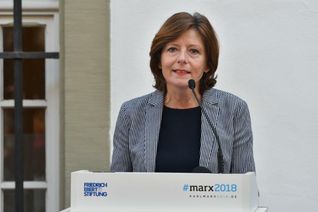 Manfred Jehnen (v.l.), Wolfgang Kreckler (mit dem neuen Buch) und Rainer Helfen von den Eisenbahnfreunden Jünkerath e.V. vor dem großen Roheisenpfannenwagen und der Dampflok-Treibachse im Außenbereich des Eisenbahnmuseums in Jünkerath. 	Foto: Woltmann