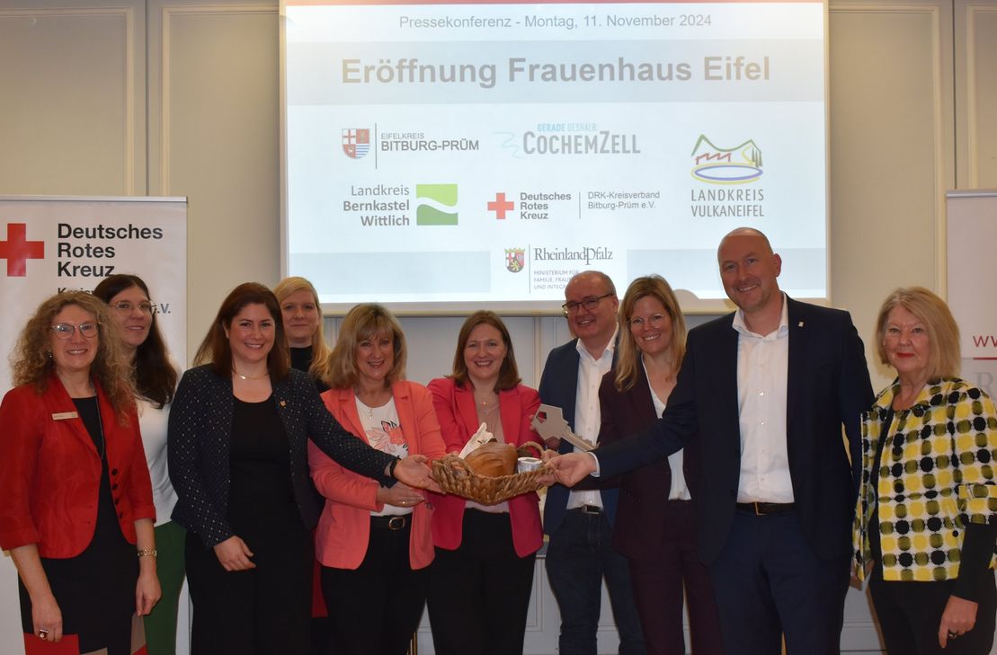 Die Vertreter und Gleichstellungsbeauftragten der beteiligten Landkreise, der Geschäftsführer des DRK-Kreisverbandes Bitburg-Prüm Rainer Hoffmann sowie Frauenministerin Katharina Binz bei der symbolischen Schlüsselübergabe in Bitburg.