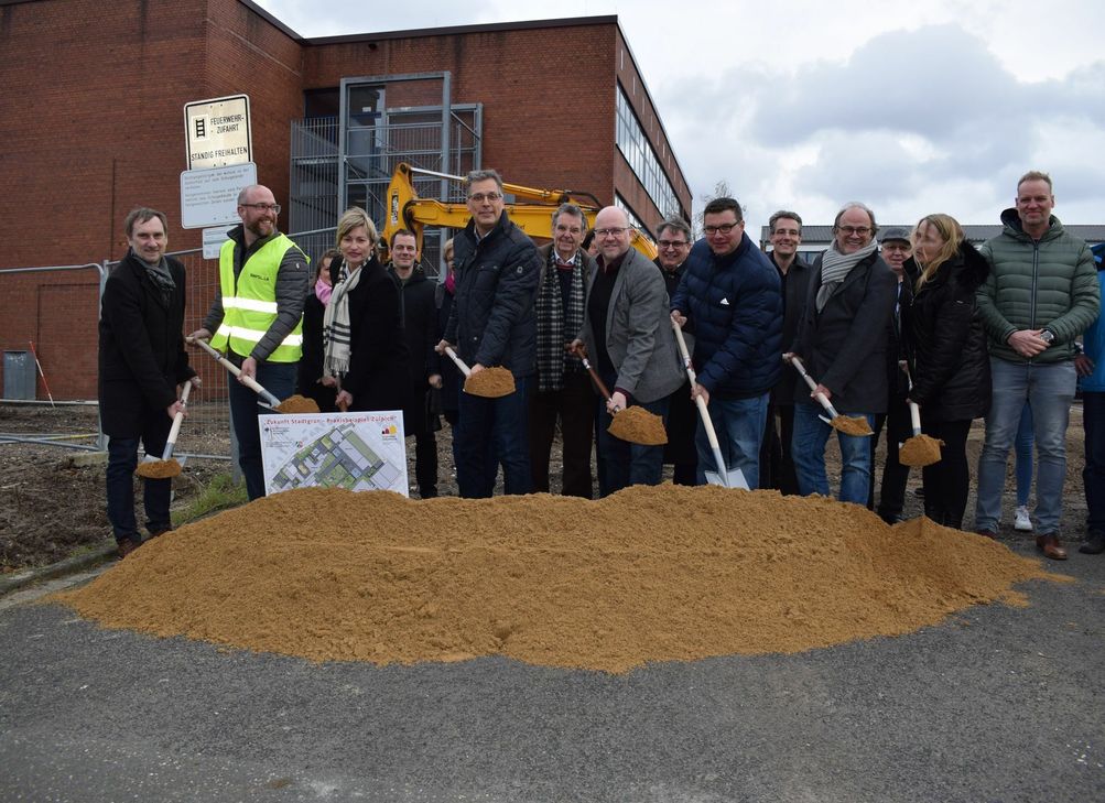 Nahmen im Beisein zahlreicher Vertreter von Rat, Schulen und Verwaltung den ersten Spatenstich zur Umgestaltung des Schulcampus Zülpich vor (mit Spaten v.l.): Beigeordneter Ottmar Voigt (Stadt Zülpich), Claas Scheele (RMP Stephan Lenzen Landschaftsarchitekten), Schulleiterin Ursula Pielen (Gemeinschaftshauptschule), Bürgermeister Ulf Hürtgen, Schulleiter Joachim P. Beilharz (Franken-Gymnasium), Timm Fischer (Vorsitzender Ausschuss für Schulen, Soziales, Sport und Kultur), Frank Weindorf (Weindorf Garten-, Landschafts- und Sportplatzbau GmbH) und Schulleiterin Raphaela Kehren (Karl-von-Lutzenberger-Realschule). Foto: Stadt Zülpich / Torsten Beulen