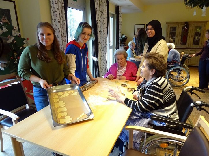 Fabienne Endres(von links), Elisabeth Rylskij und Mariam Mohamad backen gemeinsam mit den beiden Hausbewohnerinnen Helena Heinz und Renate Ruster Plätzchen. Foto: Mohsmann