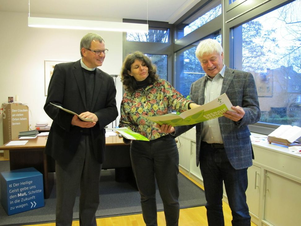 Klimamanagerin Charlotte Kleinwächter überreicht Generalvikar Dr. Ulrich Graf von Plettenberg (links) im Beisein von Dr. Gundo Lames die Energieberichte. Foto: Bistum Trier