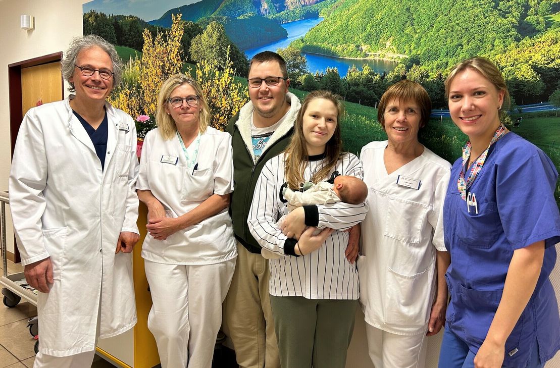 Chefarzt Dr. med. Andreas Cousin mit Kinderkrankenschwestern und Hebamme begrüßen das erste Baby 2024 auf der geburtshilflichen Station der Eifelklinik in Simmerath: Die kleine Elli mit ihren Eltern, Jennifer und Philip Linzenich aus Hürtgenwald-Straß.
