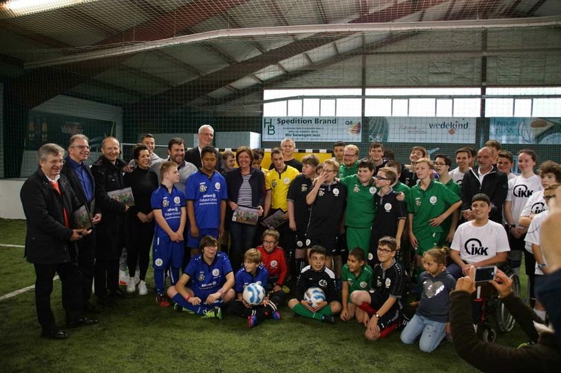 Ortsbürgermeister Rainer Müller (v.l.n.r.); Rudolf Körner, Beigeordneter der VG Schweich; Wolfgang Enderle; Boris Cucka (Inhaber des BC Sports Center Kenn und Förderer des Team Bananenflanke Trier) und Familie; Oberbürgermeister Wolfram Leibe; Ministerpräsidentin Malu Dreyer; Hans Dorobek; Fabian Poltrock; Spieler in Blau/Gelb: Team Bananenflanke Bonn-Rhein-Sieg e.V.