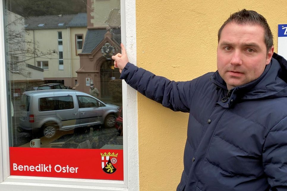 Der Landtagsabgeordnete Benedikt Oster zeigt die Beschädigung am Fenster seines Abgeordnetenbüros.