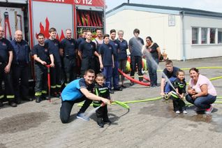 Ein Traum geht für den kleinen Dominik Warga (hier mit Vater Herbert, Schwester Jessica, Mama Larissa und den Hermeskeiler Wehrleuten) in Erfüllung, als er bei der Hermeskeiler Feuerwehr ein richtiges Feuer löschen konnte. Die improvisierte Löschübung wurde durch die Aktion Bruno Bear und der Mutterhaus-Klinik Trier möglich. Foto: Fischer