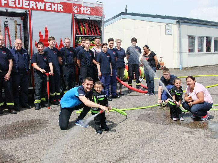Ein Traum geht für den kleinen Dominik Warga (hier mit Vater Herbert, Schwester Jessica, Mama Larissa und den Hermeskeiler Wehrleuten) in Erfüllung, als er bei der Hermeskeiler Feuerwehr ein richtiges Feuer löschen konnte. Die improvisierte Löschübung wurde durch die Aktion Bruno Bear und der Mutterhaus-Klinik Trier möglich. Foto: Fischer