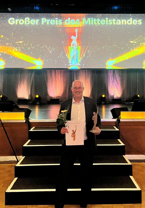 Dr. Wolfgang Schlags präsentiert die Auszeichnung.