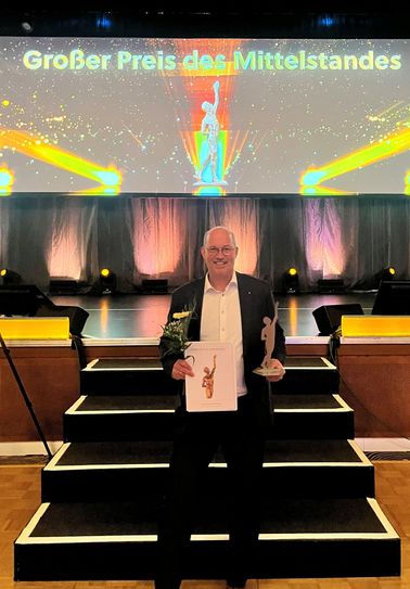 Dr. Wolfgang Schlags präsentiert die Auszeichnung.