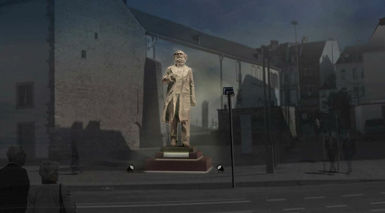 Die Visualisierung zeigt, wie der Sockel der Statue voraussichtlich aussehen wird und wie sie bei Nacht angeleuchtet werden soll: Zwei schwächere Strahler, die (entgegen des Fotos) im Boden eingelassen sind, leuchten von unten, während ein höherer Mast mit einem starken Spot das Gesicht anstrahlt. Visualisierung: Wu Weishan