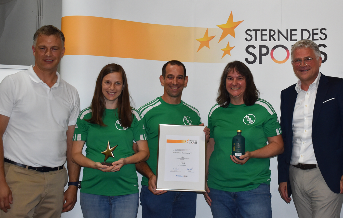 Detlef Maiers (links) und Andreas Theis (rechts) gratulieren den Vertreterinnen und dem Vertreter des SV Eifelland Orenhofen zum "Stern des Sports in Bronze"