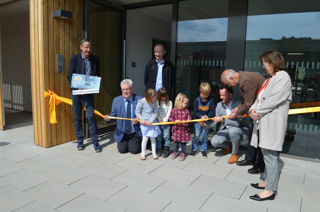 Von links: KiTa-Leiter Robert Nohn, Baudezernent Andreas Ludwig, Lebenshilfe-Vorstand Wolfgang Enderle, EGP-Chef David Becker, Ortsvorsteher Bernd Michels und Bürgermeisterin Elvira Garbes durchschneiden gemeinsam mit den Kindern der KiTa das Band am Eingang der neuen Kindertagesstätte. Foto: Fischer
