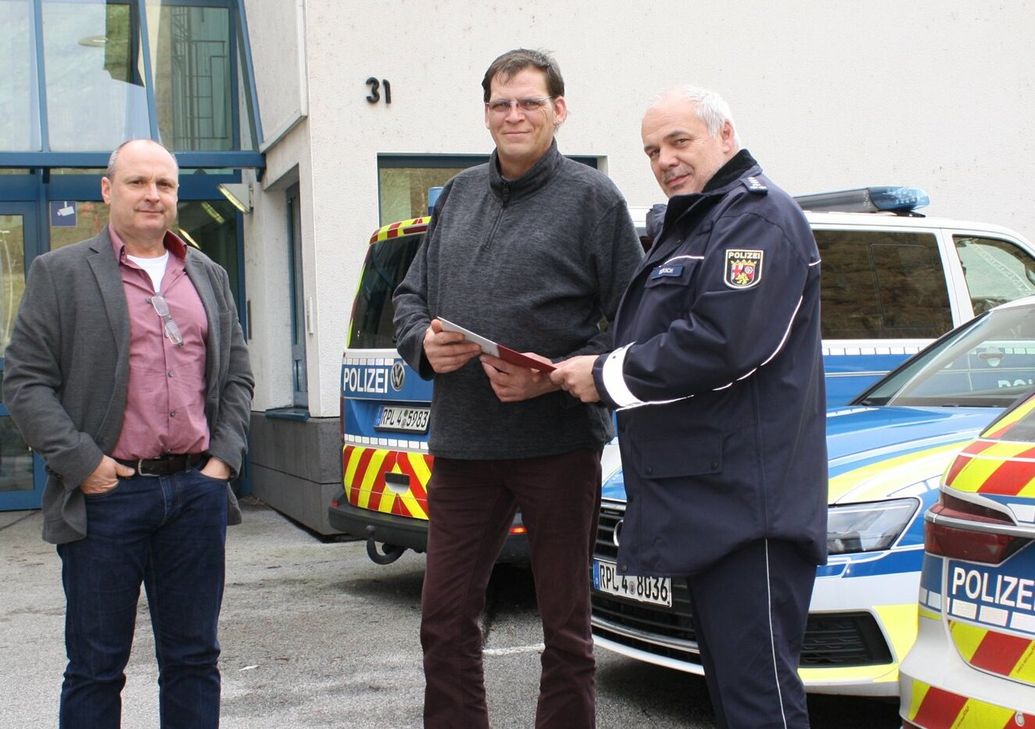 Reinhard Börsch (rechts), Leiter der Polizeiinspektion Cochem,  und Kriminalhauptkommissar Norbert Flick (links) haben Michael Zimmermann die »Bürgerurkunde« des Polizeipräsidenten für sein couragiertes Verhalten überreicht.