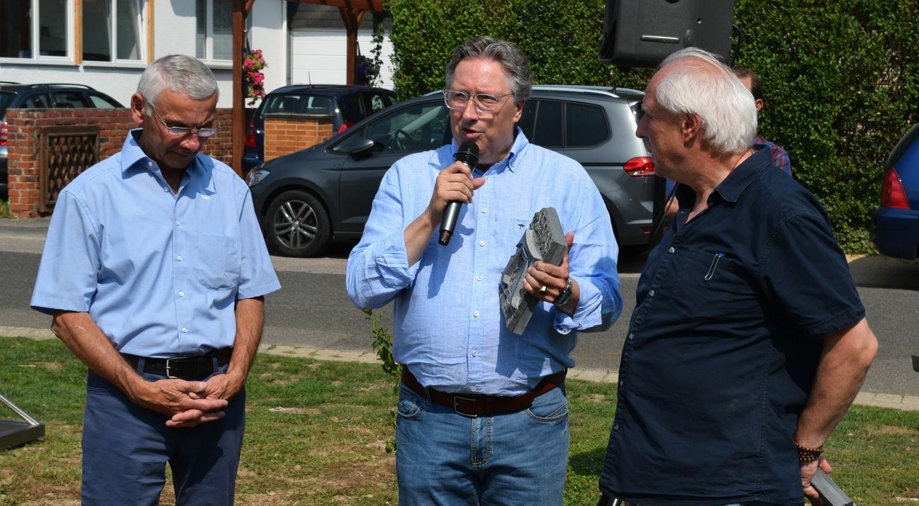 Ein Albrecht-Dürer-„A“ aus der Bodenplatte des „Raumflüsterers“ schenkte Kluenter (re.) Rolf K. Emmerich (Mitte) und dem Kuratoriumsvorsitzenden Kurt Schmidt (beide HPZ „Haus Lebenshilfe“ in Bürvenich). Foto: Scholl