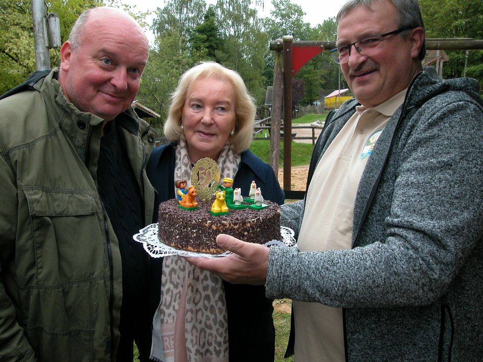 Winfried Kisters (re.) - gemeinsam mit seiner Frau einer der engagierten Helfer - überreichte Markus Wallpott und seiner Mutter Annemie eine selbstkreierte Buttercremetorte zum Zoo-Geburtstag.