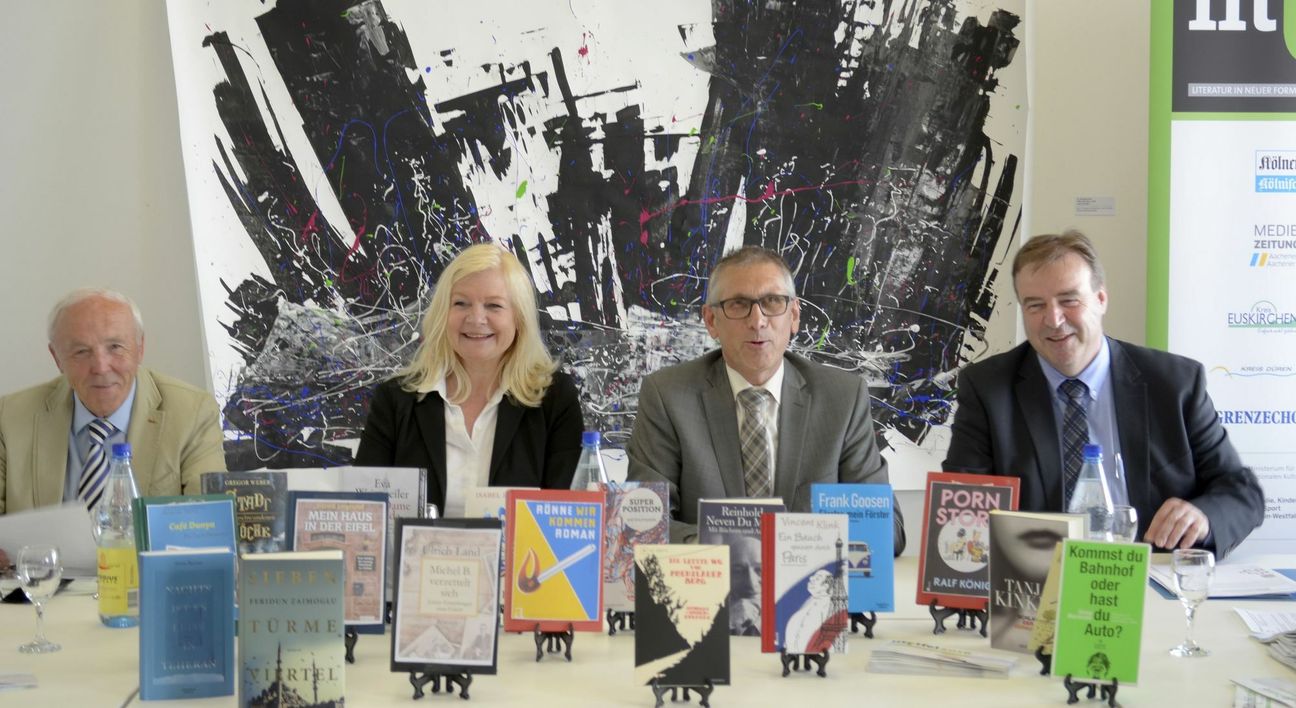Die Organisatoren der Lit.Eifel am Büchertisch mit einigen der Werke, die von spannenden Autoren an außergewöhnlichen Orten präsentiert werden.