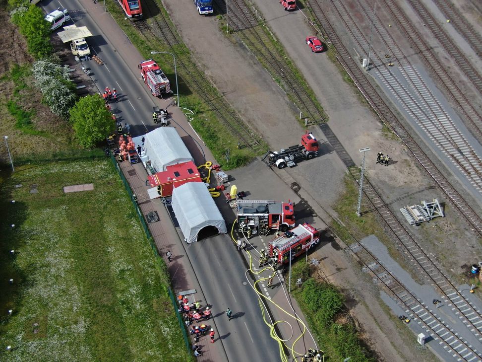 Zwei Feuerwehrleute bei Löscharbeiten auf dem Bahnhofsgelände.