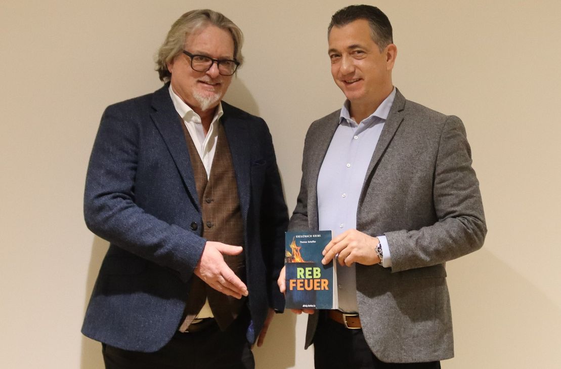 Autor Thomas Scheffler übergibt seinen neuen Krimi "Rebfeuer" an Oberbürgermeister Emanuel Letz.