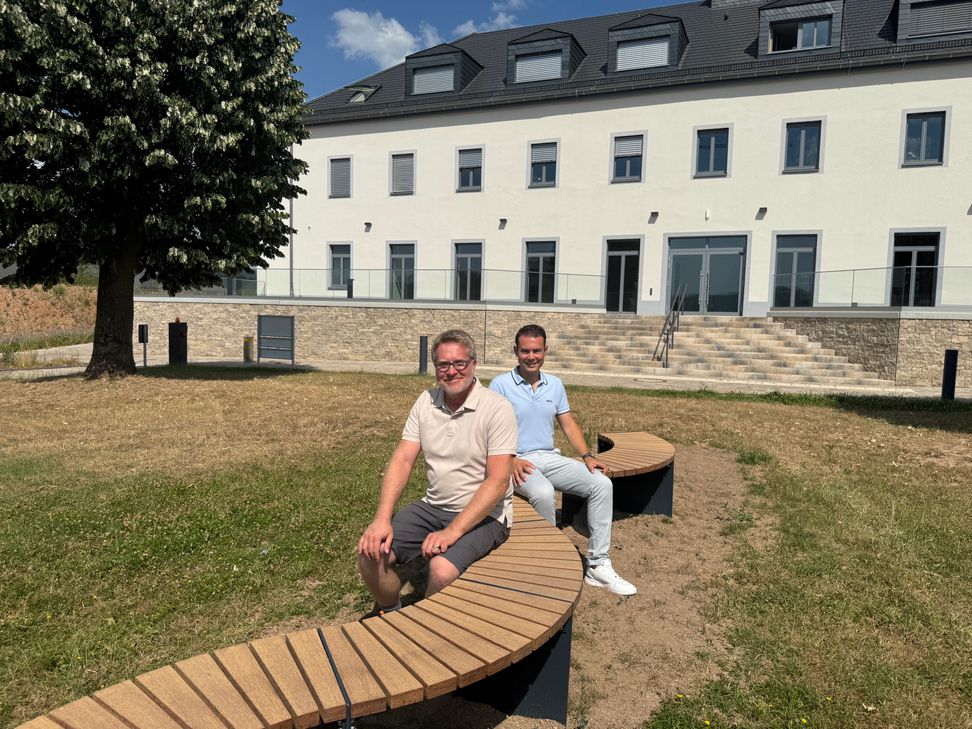 Stadtbürgermeister Andreas Reymann und Beigeordneter Alexander Burger testen die "Schlangenbank" aus.