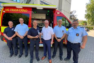 Bürgermeister Holstein überreicht dem Leiter der Führungsstaffel, Marc Bente, den Schlüssel zum neuen Einsatzleitwagen.