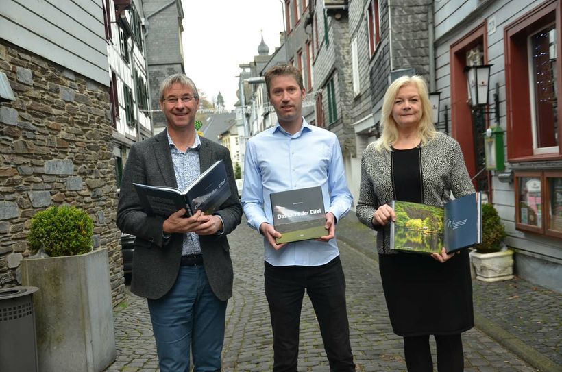 Die Eifel aus einem neuen und faszinierenden Blickwinkel betrachten Guido Bertemes (Grenz-Echo Verlag), Fotograf Andreas Gabbert und Monschaus Bürgermeisterin Margareta Ritter. Foto: T. Förster