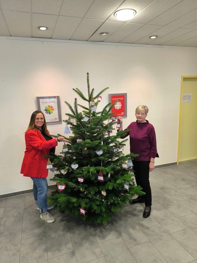 Susanne Breitbach, MGH-Koordinatorin, (l.) und Sylvia Bell, Wunschbaum-Ehrenamtliche (r.), freuen sich mit dem gesamten Wunschbaum-Team, dass die Aktion nun startet.