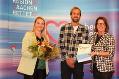 Ulla Thönnissen mit Laura Löbb und Michael Heck, die für den Garten- und Landschaftsbau H. Müller die Auszeichnung der Initiative »Region Aachen rettet« entgegen nahmen. Sie wurden für die Finanzierung eines Defibrillators in Rollesbroich geehrt.