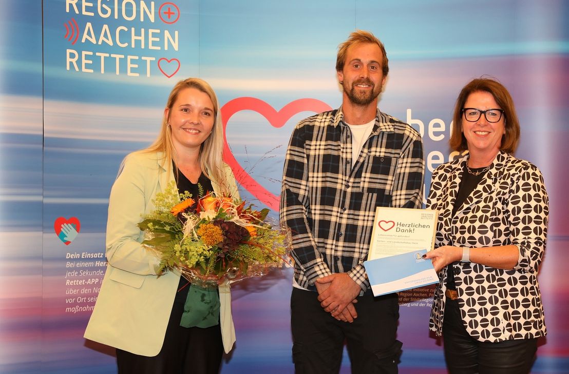 Ulla Thönnissen mit Laura Löbb und Michael Heck, die für den Garten- und Landschaftsbau H. Müller die Auszeichnung der Initiative »Region Aachen rettet« entgegen nahmen. Sie wurden für die Finanzierung eines Defibrillators in Rollesbroich geehrt.