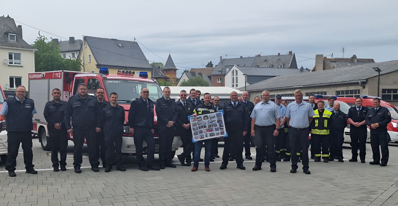 Inmitten der Floriansjünger aus der Verbandsgemeinde Vordereifel freut sich Bürgermeister Timo Kanzinger (Mitte, mit Fotorahmen) über die gelungene Überraschung beim Antrittsbesuch der Freiwilligen Feuerwehren zu seinem Amtsbeginn.