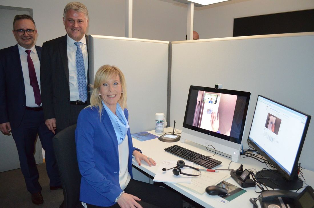 Die Volksbank Eifel eG-Vorstände Michael Simonis und Andreas Theis (v.l.) stellen die größte Neuerung im Umstrukturierungsprozess der Bank vor: Mitarbeiter wie Silke Parsch erfüllen vom VR-SISy-Büro in der Volksbank in Prüm über digitale Kanäle Wünsche von Kunden, die ihnen direkt per Videosystem aus VR-SISy-Filialen zugeschaltet sind.  Foto: S. Schönhofen