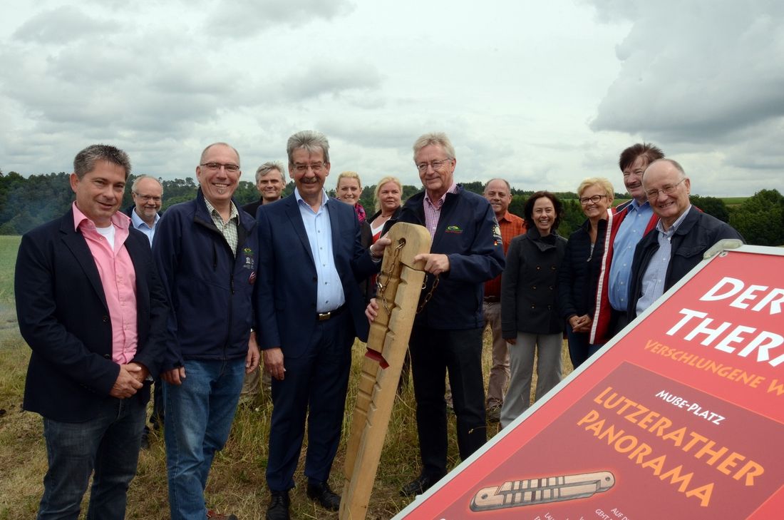 Die Teilnehmer der Pressekonferenz mit überdimensionalem Kerbholz, dem Symbol des Maare-Thermen-Pfades, auf dem vom Kampf der Elemente Feuer, Wasser, Luft und Erde, aber auch von den Untaten der berüchtigten Moselbande um den Schmied Johann Sebastian Nikolai, den Pferdedieb Lorenz Günter und dem so genannten "Tuchhannes" die Rede ist.