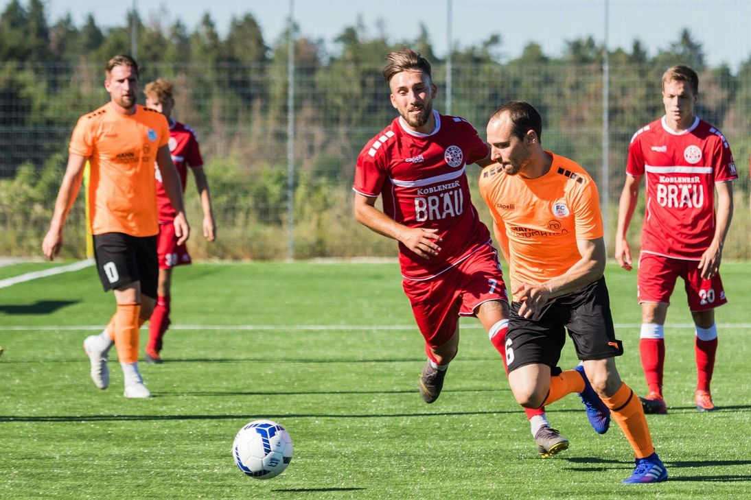 Noch sind die Farben der neuen orangen Karbach-Trikots für die Fans sicher gewöhnungsbedürftig, der neue Kunstrasenplatz, auf dem Tim Puttkammer um den Ball gegen die Koblenzer kämpfte, bietet nun aber für die Hunsrücker ausgezeichnete Trainingsmöglichkeiten für die laufenden Saisonvorbereitungen. (Foto: Arno Boes)