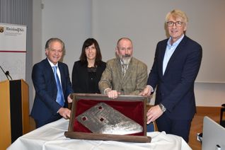 Von links: Dr. Andreas Nikolay, Kistina Müller-Bongard, Stephano Borrero Wolff und Uwe Lederer präsentieren die historische Fallbeilschneide.