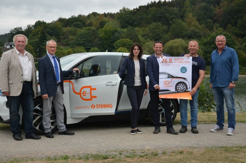 Die Organisatoren der STAWAG freuen sich mit Bürgermeister Karl-Heinz Hermanns (2.v.l.), Rurbergs Ortsvorsteher Sander Lutterbach (3.v.r.) und Vertretern der Eifeler Kultband »Billy Boys« auf »Rursee e-mobil«, eine Mischung aus Information über Elektromobilität und kulturellen Highlights.