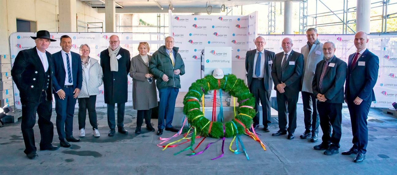Der Richtkranz dient als Symbol des stolzen Bauherrn und wird ab sofort das Gebäude der Junior Uni Daun schmücken. Von links: Florin Stoll (Zimmerermeister), Tyrone Winbush (stellv. Vorstandsvorsitzender der LEPPER Stiftung), Irene Roth (Kuratoriumsmitglied der LEPPER Stiftung), Dr. med. Heinz-Josef Weis (stellv. Kuratoriumsvorsitzender der LEPPER Stiftung), Doris G. Lepper (Vorstandsvorsitzende der LEPPER Stiftung), Peter Lepper (Kuratoriumsvorsitzender der LEPPER Stiftung und Gründer und Geschäftsführer Techniropa Holding GmbH), Prof. Dr. Helmut Willems (Mitglied im Entwicklungsteam Junior Uni Daun), Friedhelm Marder (Bürgermeister der Stadt Daun), Stefan Kön (Geschäftsführer Techniropa Holding GmbH), Prof. Dr. Rudi Balling (Mitglied im Entwicklungsteam Junior Uni Daun), Thomas Scheppe (Bürgermeister der Verbandsgemeinde Daun).