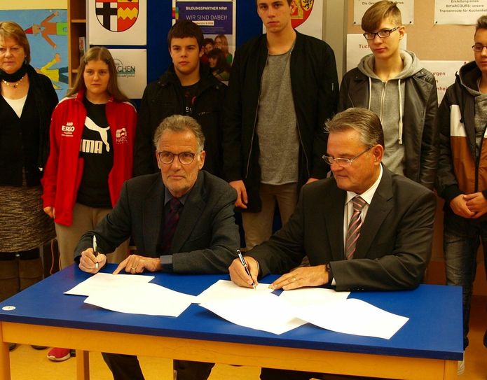 Der Bürgermeister der Kreisstadt Euskirchen, Dr. Uwe Friedl, als Archivträger und der Landrat des Kreises Euskirchen, Günter Rosenke, als Schulträger unterzeichnen in der Matthias-Hagen-Schule die Kooperationsvereinbarung. Foto: Kreisstadt Euskirchen