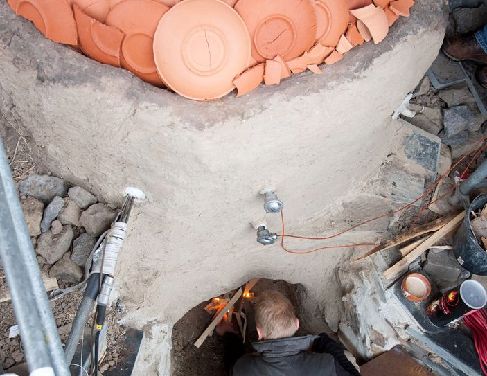 Anfeuern des rekonstruierten spätantiken Mayener Töpferofens. In den Ofen sind rund 550 Gefäße für den Brand eingesetzt worden.