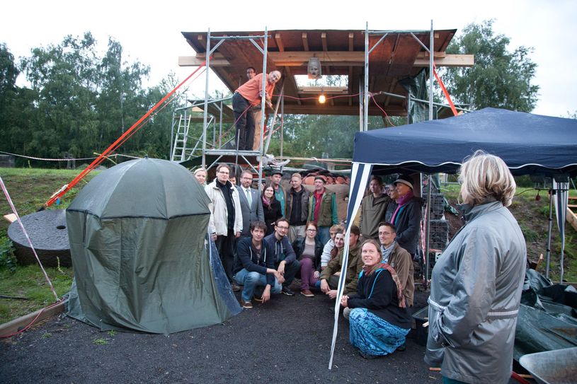 Oberbürgermeister Wolfgang Treis mit Archäologen, Geowissenschaftlern und Handwerkern vor dem Forschungsofen am Mayener Grubenfeld.