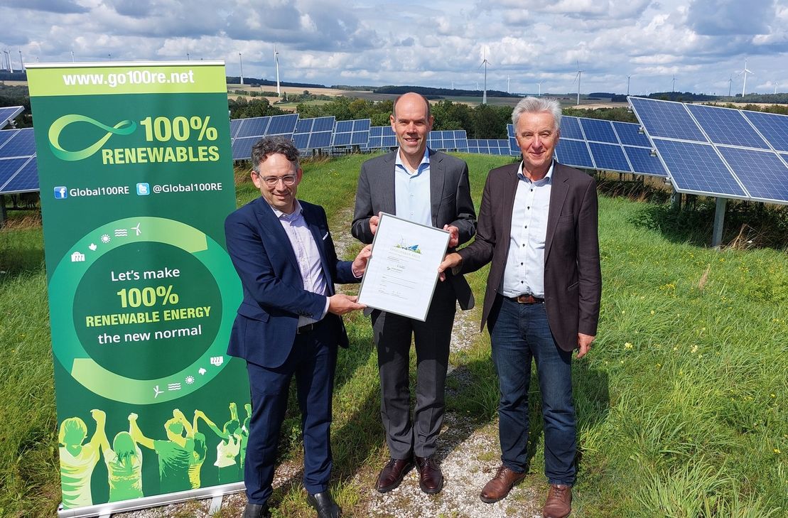 Stefan Gsänger (links), Vorstand der in Bonn ansässigen Global 100% Renewable Energy Platform und Johannes Lackmann (rechts), Mitglied im Expertenbeirat und Initiator des Projekts überreichen Landrat Volker Boch das ERNEUERBAR-Kreis Zertifikat.