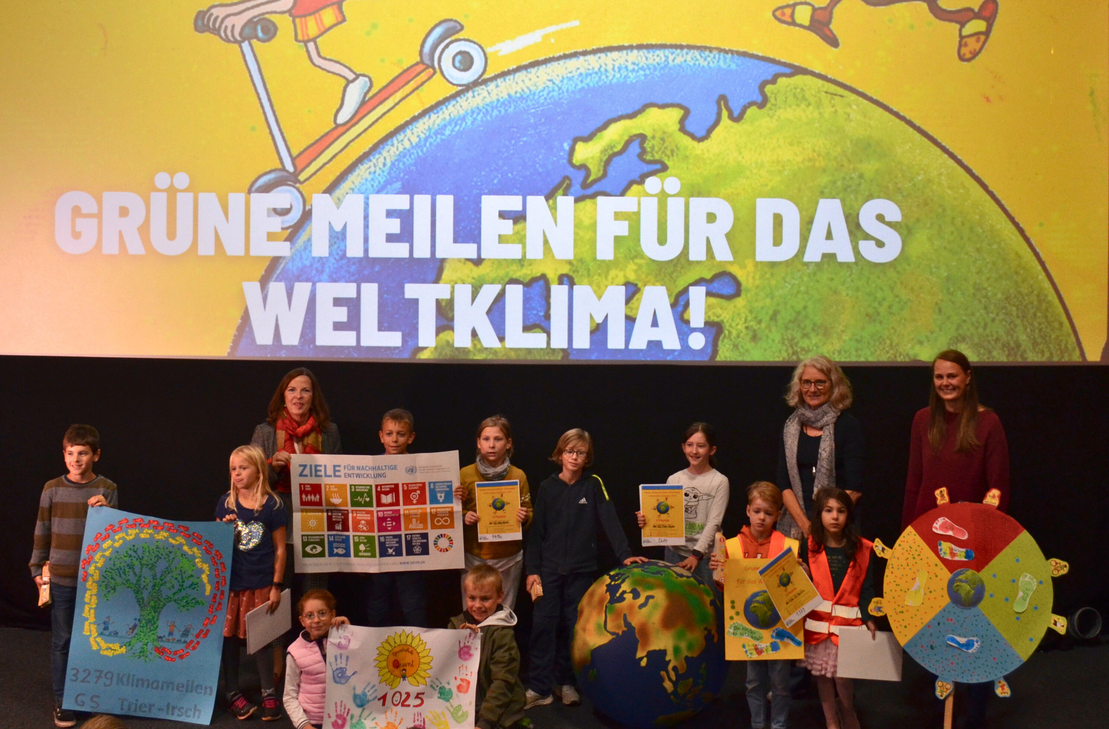 Die Kinder übergeben ihre gesammelten Meilen in Form von bunt gestalteten Plakaten.